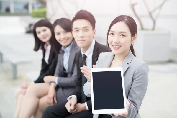 Businesspeople show tablet to you — Stockfoto