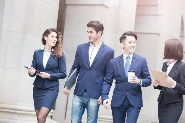 Empresários com notebook andando — Fotografia de Stock