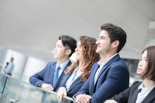 Geschäftsleute lächeln und schauen woanders hin — Stockfoto