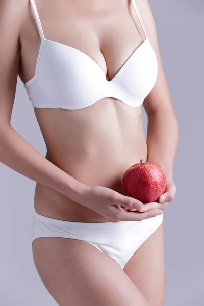Fit woman holds  apple — Stock Photo, Image
