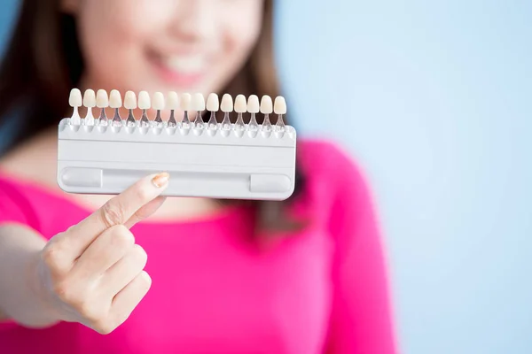 Bela mulher segurando amostra de dentes — Fotografia de Stock