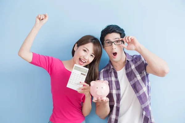 Paar holding roze varken bank en calculator — Stockfoto