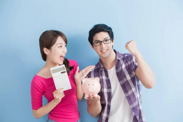 Casal segurando banco de porco rosa e calculadora — Fotografia de Stock