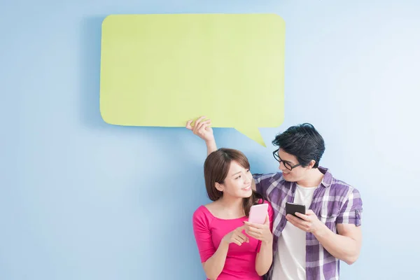 Pareja joven con teléfonos y burbuja del habla — Foto de Stock