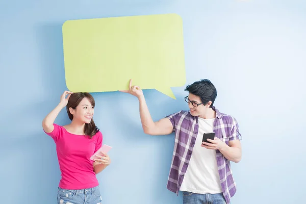 Pareja joven con teléfonos y burbuja del habla —  Fotos de Stock