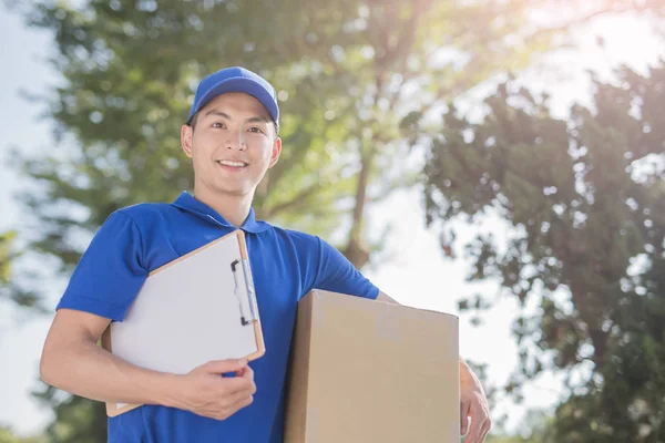 Deliveryman holding  cardboard and smiling — Stock Photo, Image