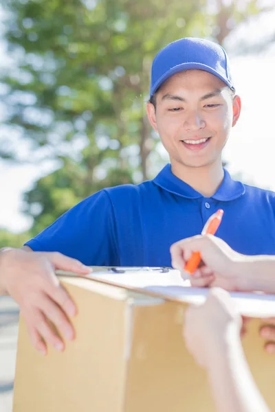 Deliveryman standing  and smiling — Stock Photo, Image