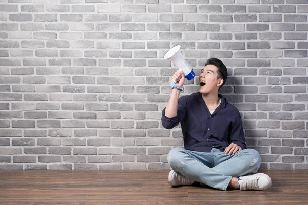 Handsome man sitting  with megaphone — Stock Photo, Image