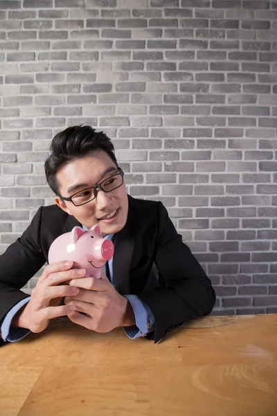 Geschäftsmann mit Sparschwein — Stockfoto