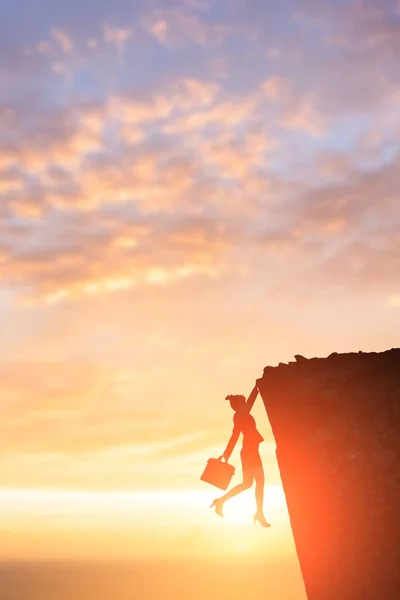 Businesswoman climbing on cliffs — Stock Photo, Image