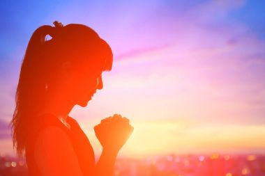 young woman praying  at  sunrise clipart
