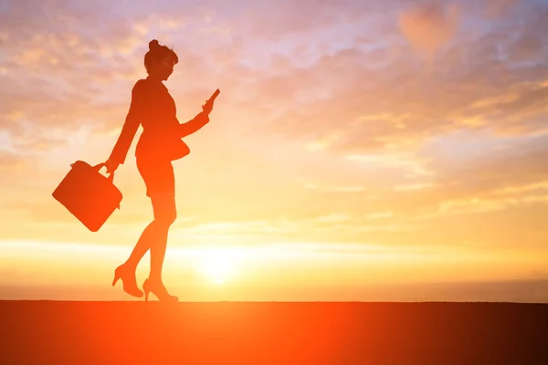Donna d'affari utilizzando il telefono al tramonto — Foto Stock