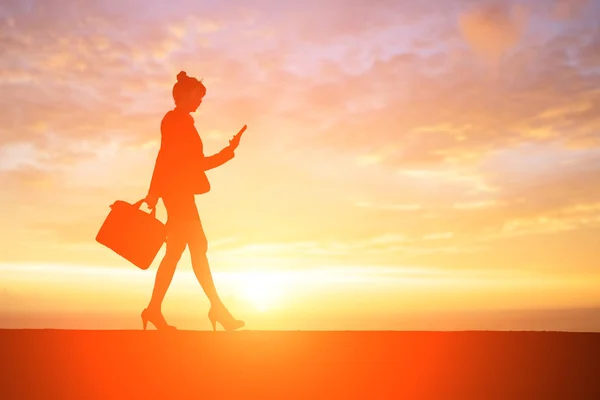 Donna d'affari utilizzando il telefono al tramonto — Foto Stock