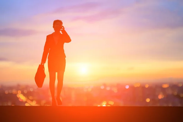 Podnikatelka, mluví o telefonu při západu slunce — Stock fotografie