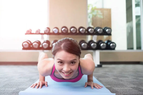 Mujer haciendo push-up en el gimnasio — Foto de Stock