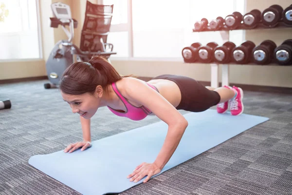 Mulher fazendo push-up no ginásio — Fotografia de Stock