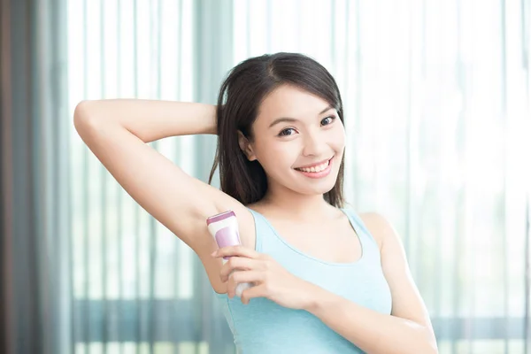 woman smiling while plucking armpit
