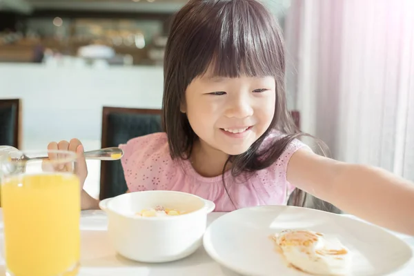 Aranyos lány eszik breakfast — Stock Fotó