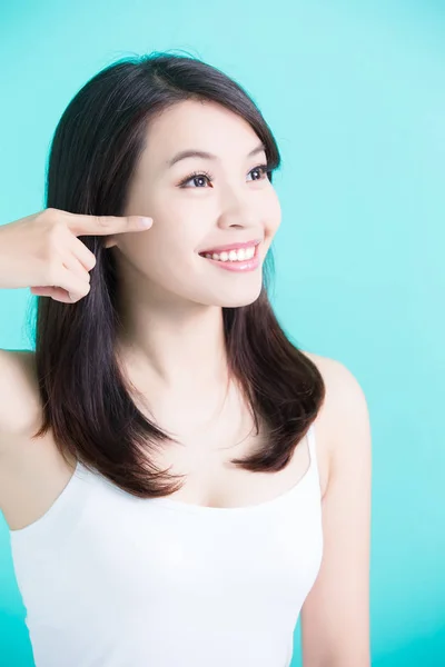 Woman pointing on cheek — Stock Photo, Image