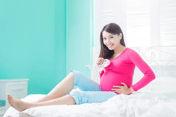 Pregnant  woman with baby shoes — Stock Photo, Image