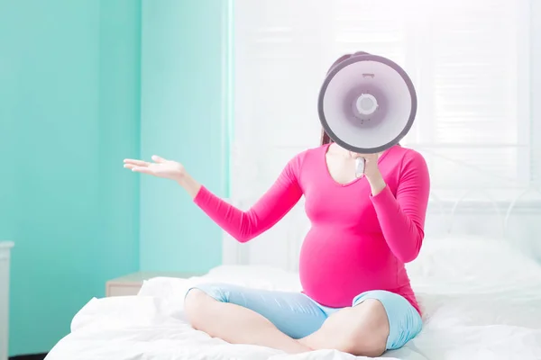 Беременная женщина с мегафоном — стоковое фото
