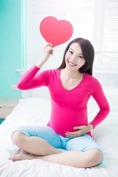 Mulher grávida segurando coração — Fotografia de Stock