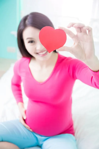 Mulher grávida segurando coração — Fotografia de Stock
