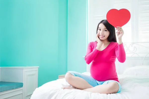 Těhotná žena hospodářství srdce — Stock fotografie