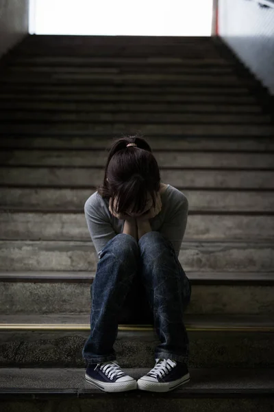 Καταθλιπτική γυναίκα που κάθεται στο υπόγειο — Φωτογραφία Αρχείου