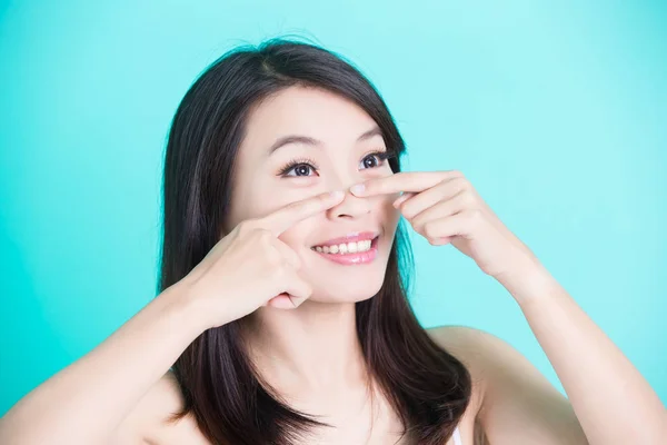 Mujer sonriendo y señalando su nariz o —  Fotos de Stock