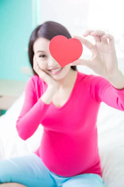 Woman with  heart on the bed — Stock Photo, Image