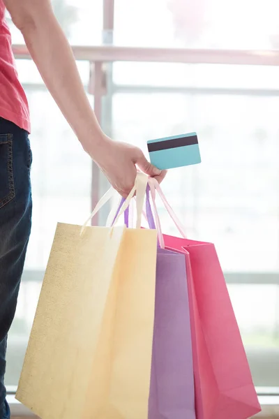 Mujer con tarjeta de crédito y bolsas — Foto de Stock