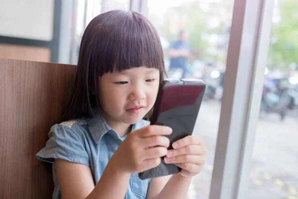 Fille en utilisant le téléphone dans le resturant — Photo