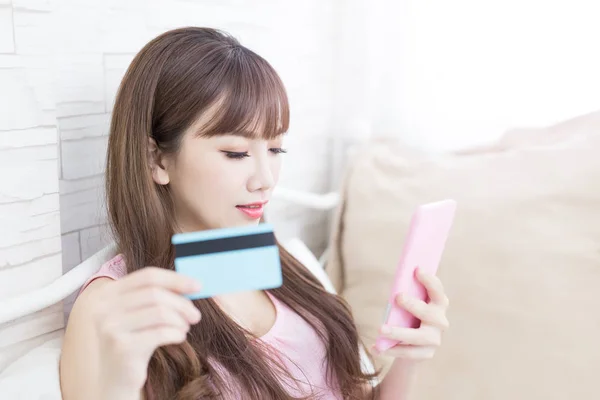 Mujer con tarjeta de crédito mirando en el teléfono — Foto de Stock