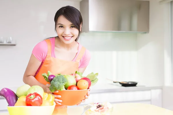 Dona de casa com legumes na cozinha — Fotografia de Stock