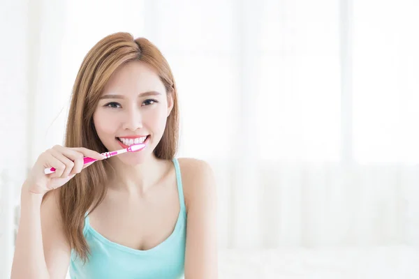 Женщина с улыбкой на зубной щетке — стоковое фото