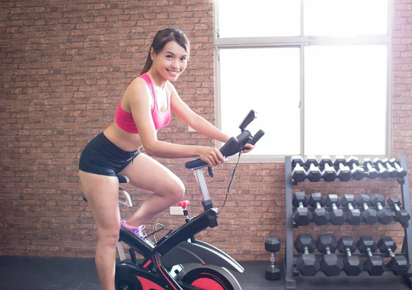 Mulher exercitando-se em bicicleta — Fotografia de Stock