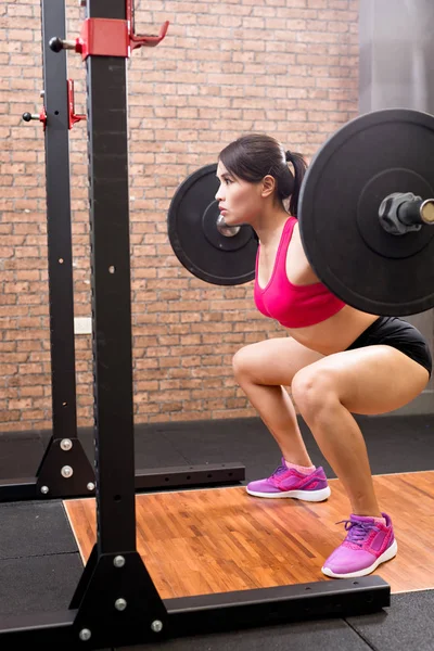 Mulher com barbell no ginásio — Fotografia de Stock