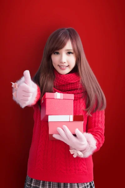 Žena s dárky ukazuje palec — Stock fotografie