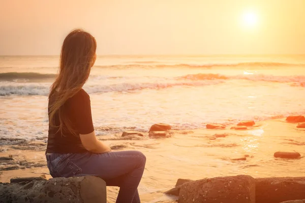 Kvinna sitter vid havet — Stockfoto