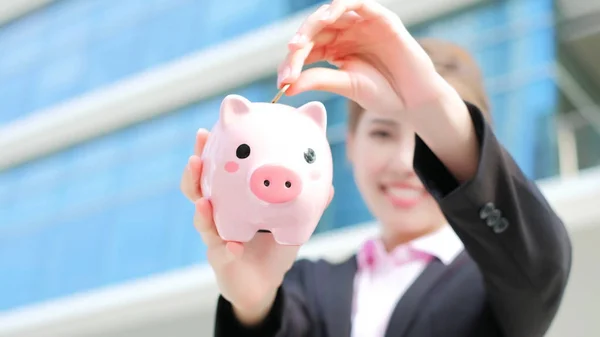 Žena drží růžové prasátko banka — Stock fotografie