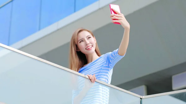 Selfietä käyttävä nainen — kuvapankkivalokuva