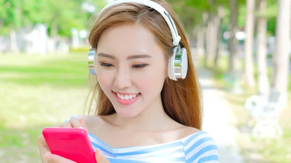 Woman listening to  music in the park — Stock Photo, Image