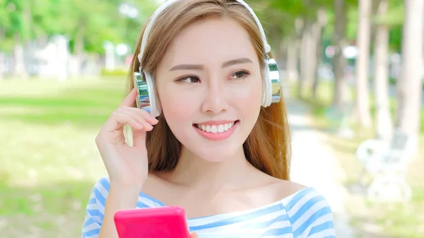 Mujer escuchando música en el parque — Foto de Stock