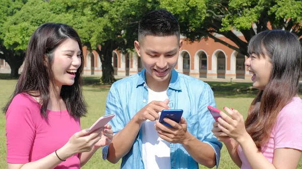 Mobiilipeliä pelaavat opiskelijat — kuvapankkivalokuva