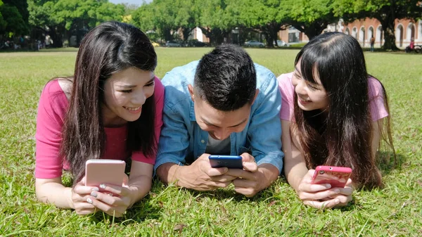 Mobiilipeliä pelaavat opiskelijat — kuvapankkivalokuva