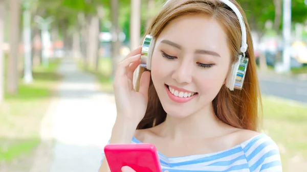 Woman listening to  music in the park — Stock Photo, Image