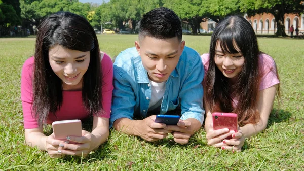 Happy students using  phones — Stock Photo, Image