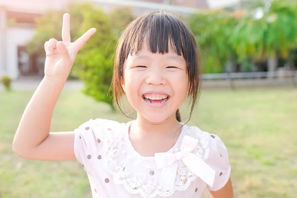 Cute girl showing victory sign Stock Photo