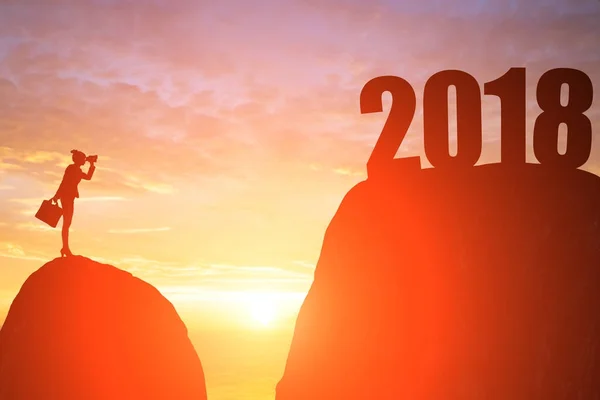 silhouette of businesswoman with  telescope on the moutain with 2018